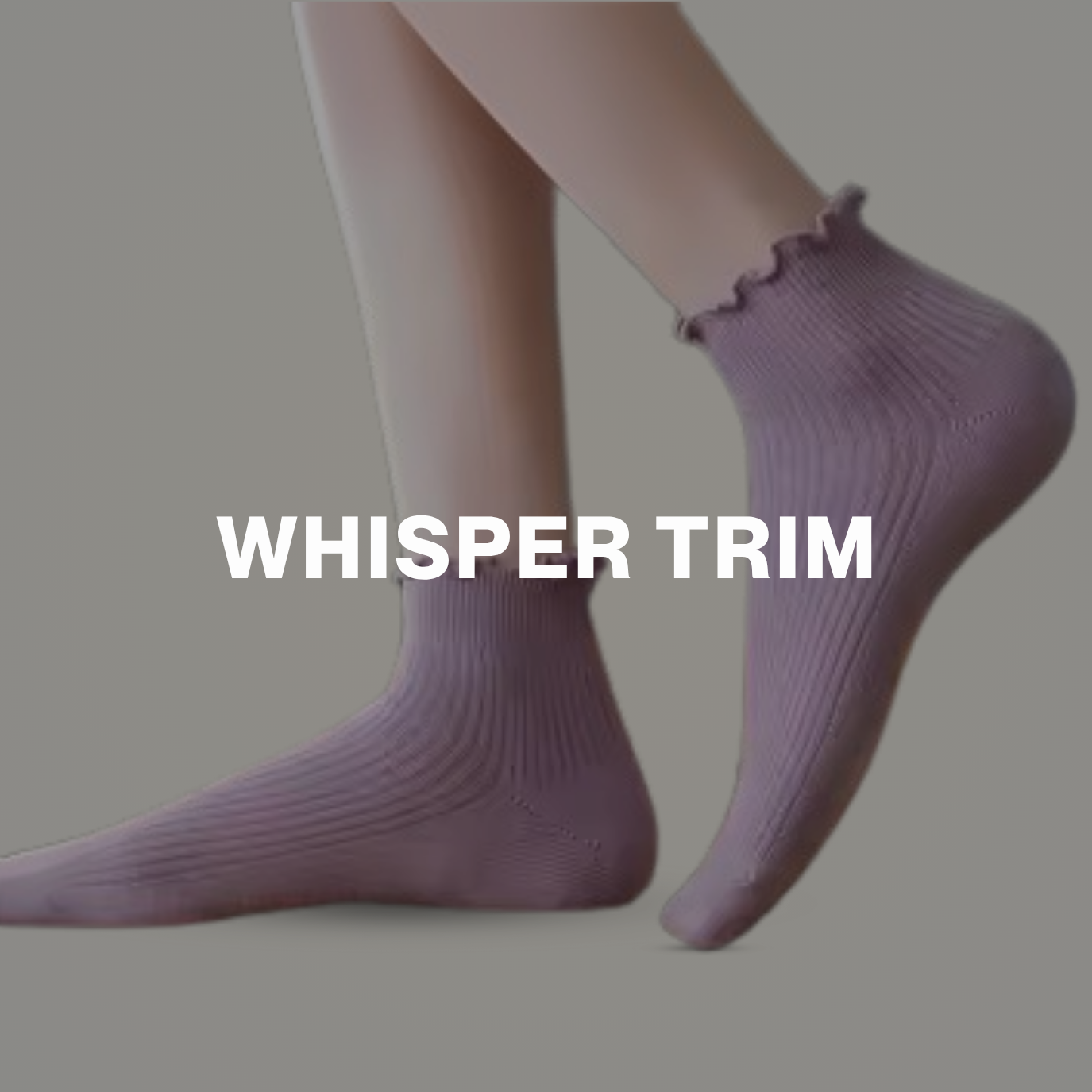 Close-up of feet wearing ribbed pastel purple socks with frill trim, styled against a soft grey background.