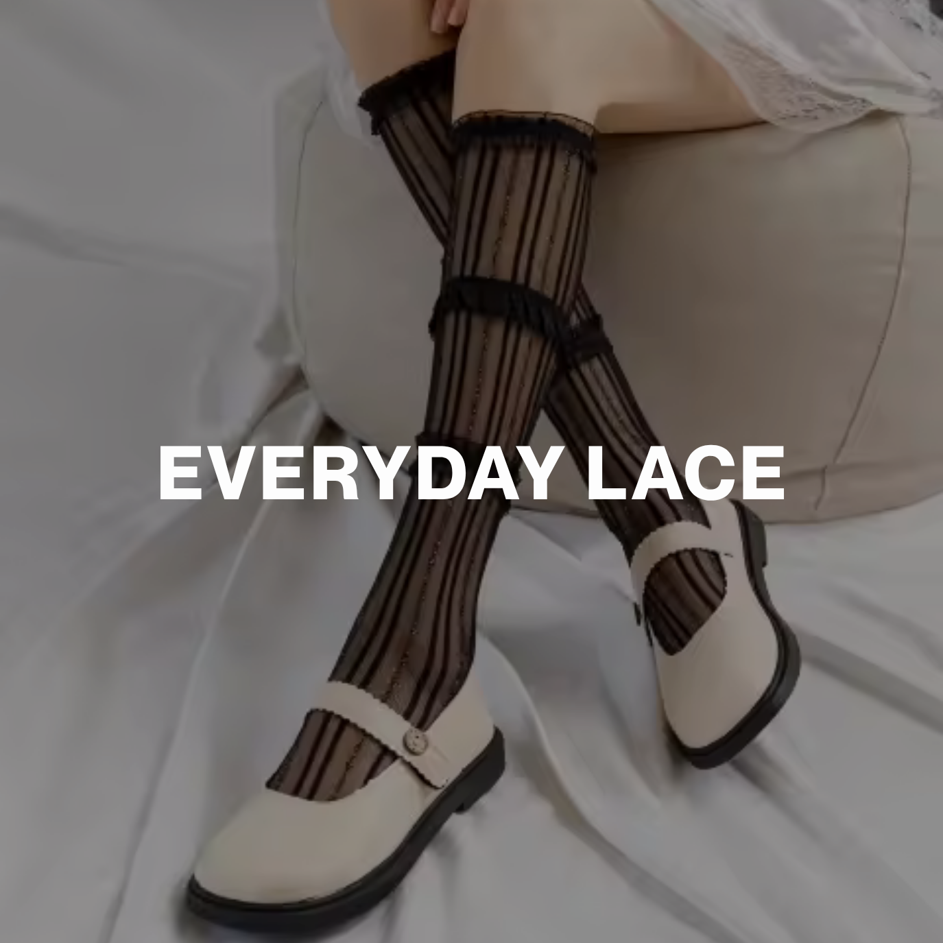 Model wearing black sheer lace knee-high socks with vertical stripes and ruffle trim, paired with cream Mary Jane shoes — labeled Everyday Lace.