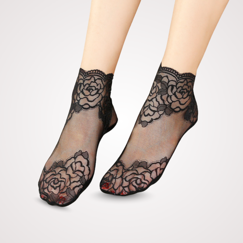 Feet wearing sheer black lace ankle socks with floral embroidery and scalloped cuffs, designed with anti-slip grip.